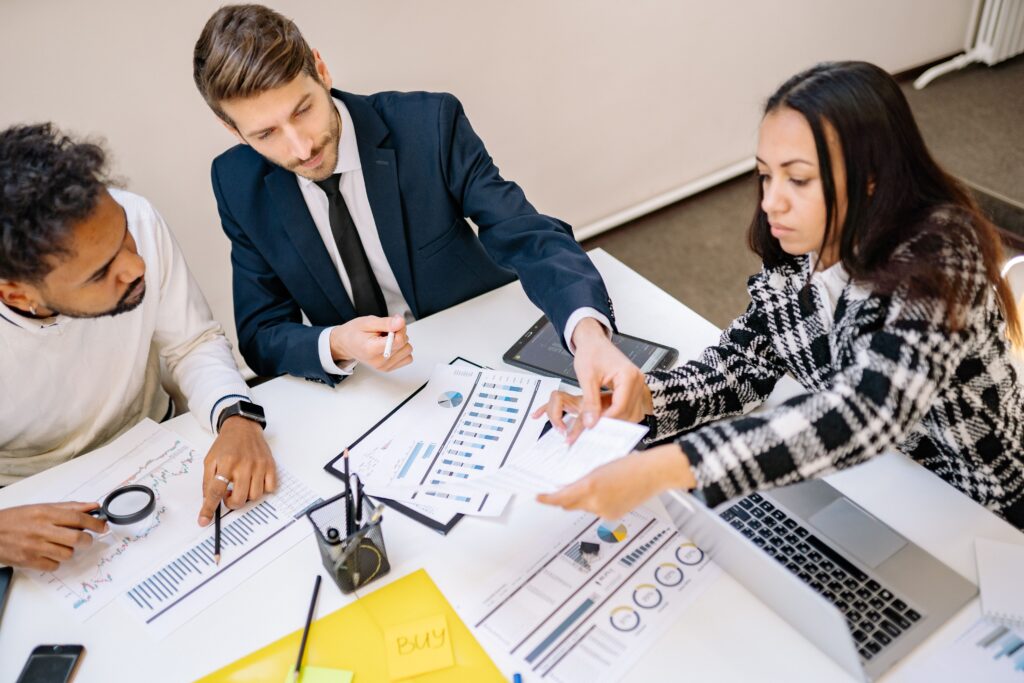 Business team reviewing financial charts and reports to catch signs of franchise royalty leakage